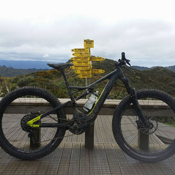 Mountain bike leaning on a lookout deck beside a yellow trail signpost